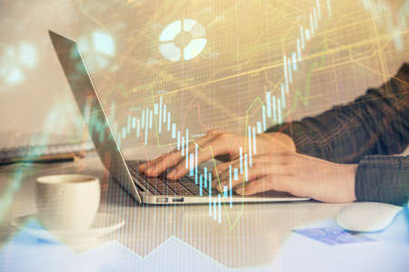 Double exposure of businesswoman hands typing on computer and forex graph hologram drawing....