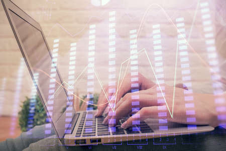 Multi exposure of woman hands typing on computer and forex chart hologram drawing. Stock market analysis concept.の写真素材