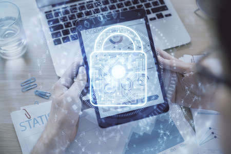Multi exposure of mans hands holding and using a digital device and lock drawing. Security concept.