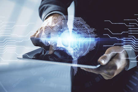 Double exposure of mans hand holding and using a digital device and brain hologram drawing. Data...