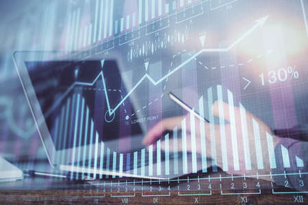Double exposure of mans hands holding and using a digital device and forex graph drawing. Financial market concept.の写真素材