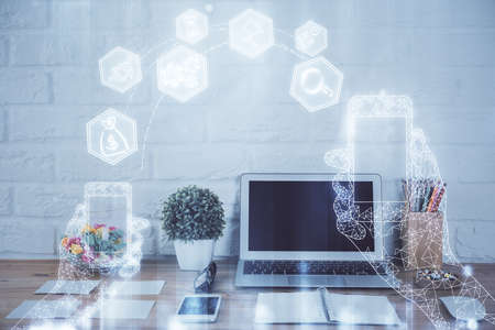 Computer on desktop in office with technology theme hologram. Double exposure. Tech concept.