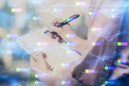 Multi exposure of woman's writing hand on background with data technology hud. Concept of innovation.の写真素材