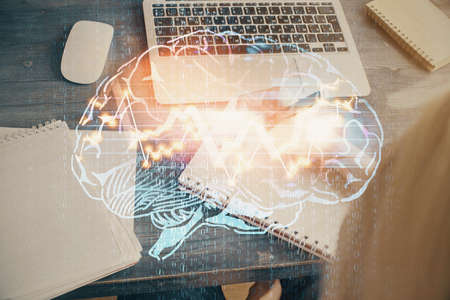 Multi exposure of writing hand on background with brain hologram. Concept of learning.の写真素材