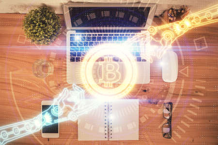 Blockchain theme hologram drawings over computer on the desktop background. Top view. Double...