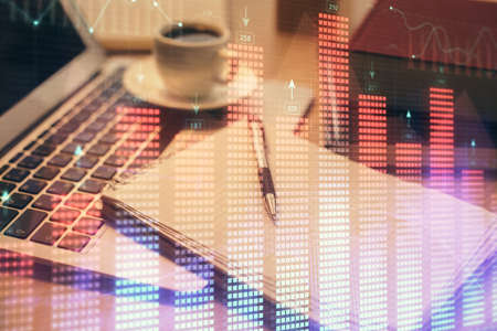 Double exposure of forex chart drawing and desktop with coffee and items on table background....