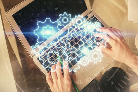 Double exposure of woman hands working on computer and financial theme hologram drawing. Top View. Business concept.の写真素材