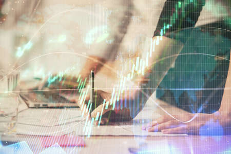 Multi exposure of woman hands typing on computer and financial chart hologram drawing. Stock market...