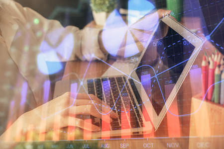 Double exposure of woman hands typing on computer and forex chart hologram drawing. Stock market...