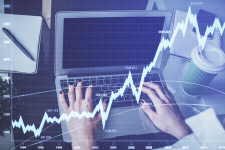 Double exposure of woman hands typing on computer and forex chart hologram drawing. Stock market...