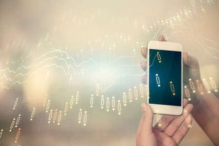 Double exposure of forex chart sketch hologram and woman holding and using a mobile device. Stock...