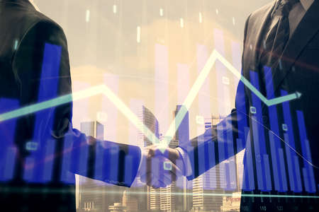 Double exposure of forex graph hologram and handshake of two men. Stock market concept.の写真素材