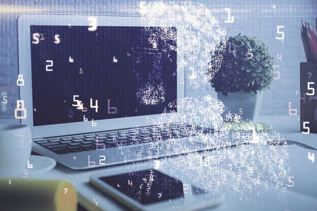 Computer on desktop in office with technology theme hologram. Double exposure. Tech concept.