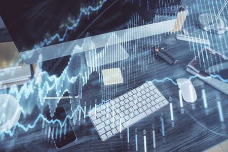 Double exposure of chart and financial info and work space with computer background. Concept of...