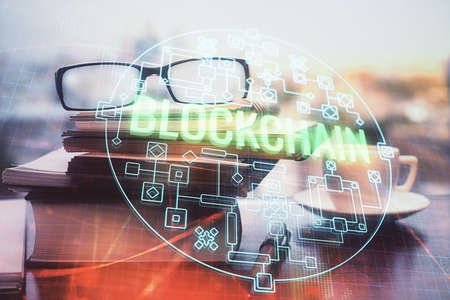 Crypto theme hologram with glasses on the table background. Concept of blockchain. Double exposure.