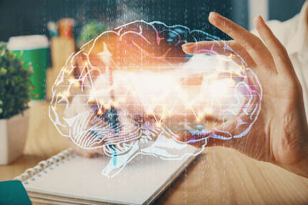 Multi exposure of writing hand on background with brain hologram. Concept of learning.
