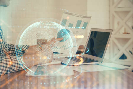 Multi exposure of world map hologram with man working on computer on background. Concept of...