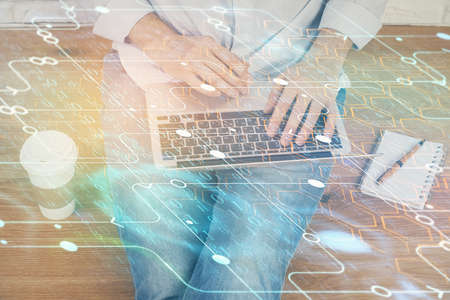 Multi exposure of data internet theme hologram with man working on computer on background. Concept...