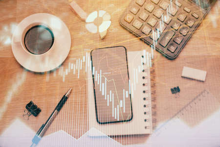Multi exposure of forex graph hologram over desktop with phone. Top view. Mobile trade platform concept.の写真素材