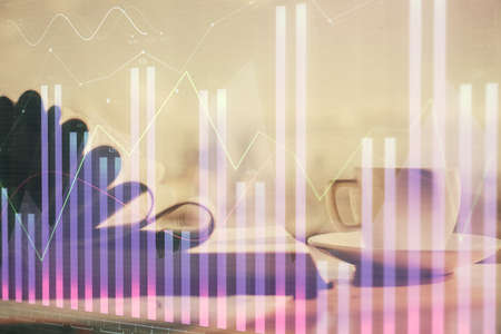 Double exposure of financial chart drawing and desktop with coffee and items on table background. Concept of forex market tradingの写真素材