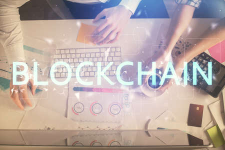 Double exposure of man and woman working together and crypto theme hologram drawing. Computer...