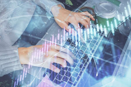 Double exposure of woman hands typing on computer and forex chart hologram drawing. Stock market...