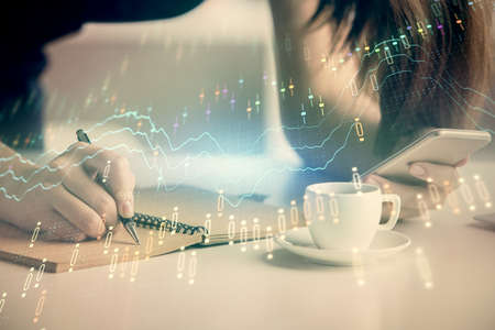 Double exposure of forex graph sketch hologram and woman holding and using a mobile device. Stock...