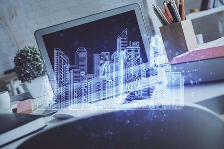 Desktop computer background in office and big town buildings hologram drawing. Double exposure. Smart city concept.の写真素材