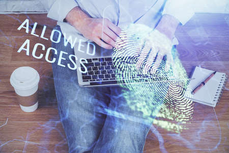 Fingerprint hologram with businessman working on computer on background. Security concept. Double...