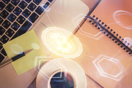 Blockchain theme hologram drawings over computer on the desktop background. Top view. Double...