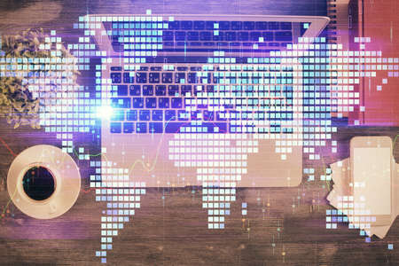 Business theme hologram drawings over computer on the desktop background. Top view. Multi exposure....