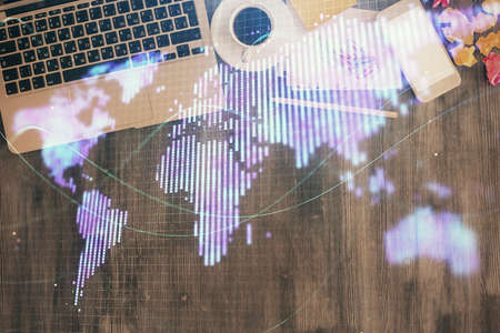 Business theme hologram drawings over computer on the desktop background. Top view. Multi exposure....