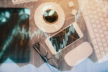 Multi exposure of forex graph hologram over desktop with phone. Top view. Mobile trade platform concept.の写真素材