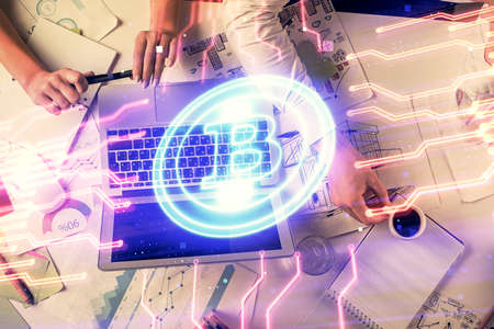 Double exposure of man and woman working together and crypto finance theme hologram. Blockchain...