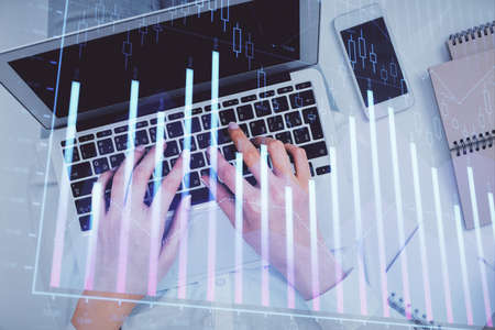 Double exposure of woman hands working on computer and forex chart hologram drawing. Top View....