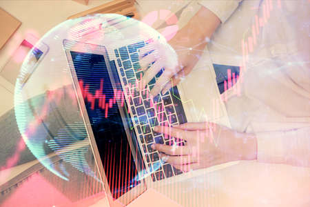 Double exposure of woman hands working on computer and financial theme hologram drawing. Top View....