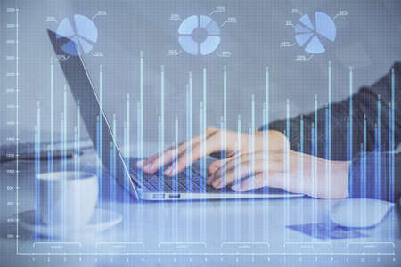 Double exposure of businesswoman hands typing on computer and forex graph hologram drawing....