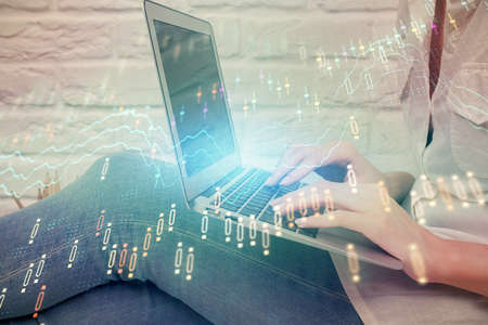 Multi exposure of woman hands typing on computer and forex chart hologram drawing. Stock market...