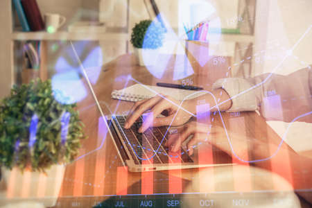 Double exposure of woman hands typing on computer and forex chart hologram drawing. Stock market invest concept.の写真素材