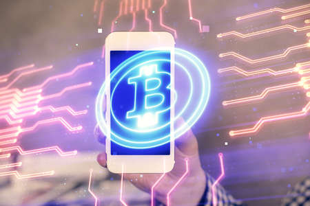 Double exposure of mans hands holding and using a phone and crypto currency blockchain theme drawing.の写真素材