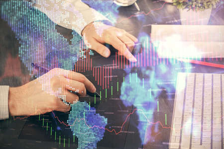 Double exposure of mans hands holding and using a phone and financial graph drawing. Analysis...
