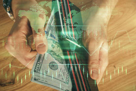 Multi exposure of forex graph drawing hologram and USA dollars bills and man hands. Technical...