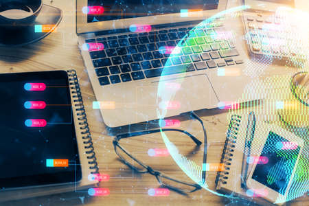 Double exposure of desktop with computer and world map hologram. International data network concept.