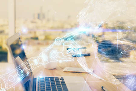 Computer on desktop in office with technology theme hologram. Double exposure. Tech concept.