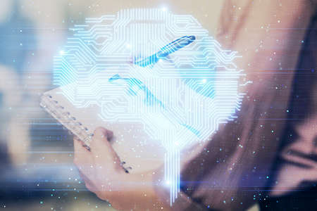 Multi exposure of woman's writing hand on background with brain hologram. Concept of brainstorming.