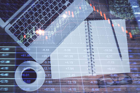 Financial market graph and top view computer on the desktop background. Double exposure. Investment...