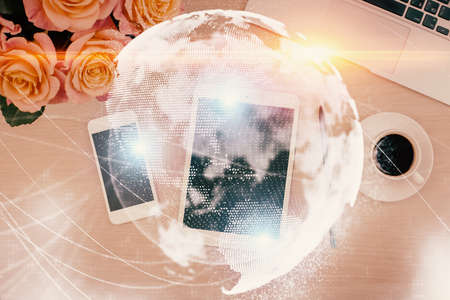 Double exposure of business theme hologram over desktop with phone. Top view. Mobile international trade connection concept.の写真素材