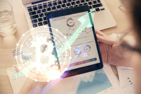 Double exposure of mans hands holding and using a phone and crypto currency blockchain theme...
