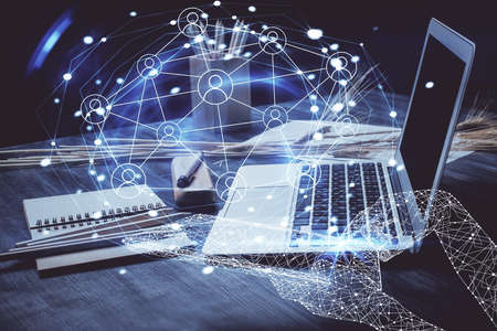 Computer on desktop with social network hologram. Double exposure. Concept of international people connections.の写真素材