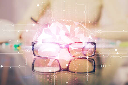 Double exposure of writing hand on background with brain hologram. Concept of learning.